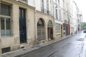 巴黎LE REGRATTIER ST LOUIS的停在街道上建筑物旁边的自行车