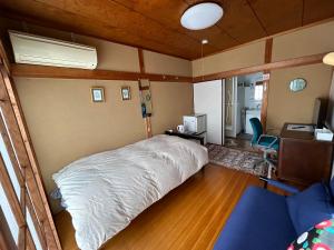 京都Sakura house的卧室配有白色的床和书桌