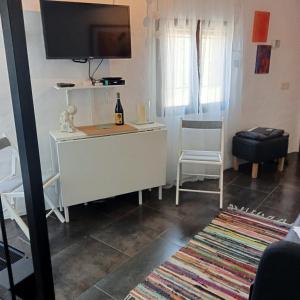 卡皮雷拉La Casita的客厅配有电视和白色书桌。
