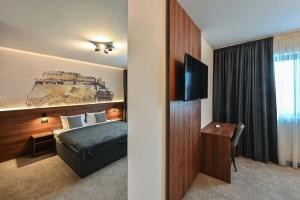 诺维萨德Tvrdjava Rooms的酒店客房,配有床和电视
