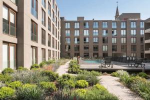 圣地亚哥Lofts Con Piscina En Santiago的建筑前方有长椅和植物的庭院