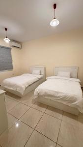 吉达Chic 3-BR Tala Almajd Villas in upscale district Alnahdah Family only的客房内的两张床和白色床单