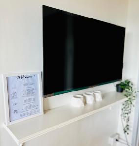 马尼拉Scandinavian design 2BR @ Ortigas, Pasig的白色架子上的平面电视