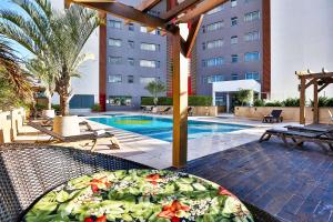 伊瓜苏维达黄金套房酒店的一个带桌子和游泳池的庭院