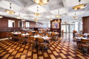 布宜诺斯艾利斯布宜诺斯艾利斯美利亚酒店的餐厅铺有木地板,配有桌椅