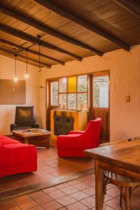 Los ÁrbolesFinca La Pichona的客厅配有红色椅子和桌子