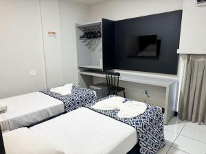 马塞约Ritz Praia Hotel的酒店客房设有两张床和一台平面电视。
