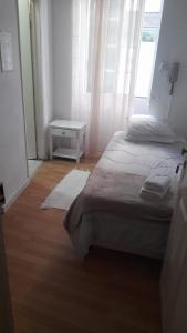 丰沙尔Hospedaria Pôr do Sol的一间卧室设有两张床、一张桌子和一个窗口