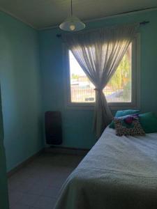特来凡林Bello Coihue的一间卧室配有床和带窗帘的窗户
