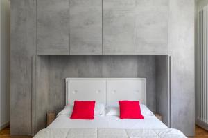 马格拉LA MAR Apartment Chirignago的卧室配有白色床和2个红色枕头