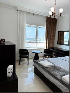 沙迦Smart Home Vacation Home- AYLA的一间卧室配有一张床、一张桌子和一张桌子