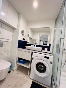 巴统Luxsor Rooms In Orbi City的一间带洗衣机和水槽的浴室