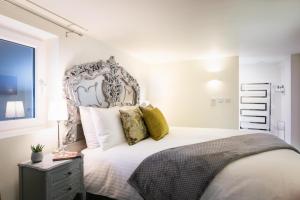 莱姆里吉斯Gorgeous Boutique Flat Sleeps 2 in Lyme Regis的卧室配有一张带黄色枕头的大型白色床。