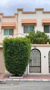 吉达Chic 3-BR Tala Almajd Villas in upscale district Alnahdah Family only的一座大楼前的一片绿色灌木丛