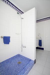 普拉亚布兰卡Sandos Atlantic Gardens的浴室铺有蓝色瓷砖地板,设有淋浴。