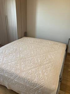 戈里齐亚Attico Verdi的一间卧室配有一张带白色床罩的床