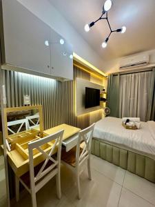 马尼拉City Nest Makati with Rooftop pool and Free Netflix的卧室配有一张床和一张桌子及椅子