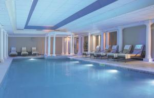 隆霍斯雷Macdonald Linden Hall Hotel, Golf & Spa的游泳池,酒店内设有椅子和游泳池