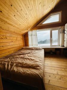 KrivopolʼyeKam In的一间设有一张床铺的木房间,设有窗户