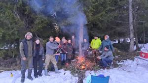 JabłonkaAgroturystyka na Słonecznej Orawie u Dzikich的一群人站在雪中的一个火堆旁