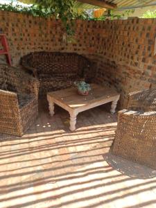 布隆方丹Shalom guesthouse的庭院配有桌子和2把藤椅
