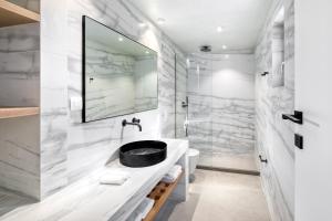 帕诺尔莫斯米科诺斯Panormos Bay Suites Luxury Resort的一间带水槽和淋浴的浴室