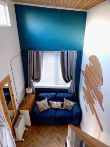 埃格林顿The Wee Tiny Home的窗户客房内的蓝色沙发