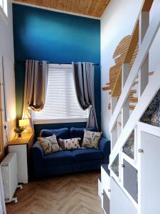 伦敦德里The Wee Tiny Home的蓝色的客房设有蓝色的沙发和窗户。