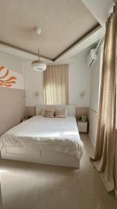 海法Dream House Art Hostel Garden and Terrace Haifa的卧室配有一张带两个枕头的大白色床