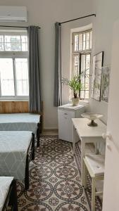 海法Dream House Art Hostel Garden and Terrace Haifa的一间卧室设有两张床、一张桌子和窗户。