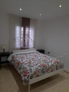 巴塞罗那SWEET HOUSE CLOSE TO AIRPORT的一间卧室配有一张带花卉床罩的床