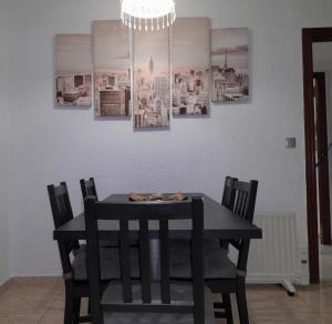 巴塞罗那SWEET HOUSE CLOSE TO AIRPORT的黑色餐桌,配有椅子和吊灯