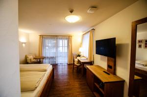 奥巴拉马高s`Wirtshaus Hotel & Restaurant的酒店客房设有一间带一张床和一张书桌的卧室