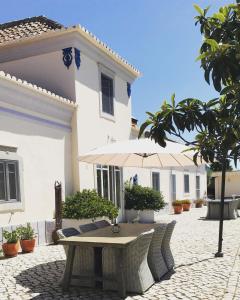 圣布拉什迪阿尔波特尔Casal da Eira的白色房子前面的一张桌子和椅子
