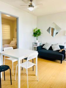 马尼拉Scandinavian design 2BR @ Ortigas, Pasig的客厅配有白色餐桌和椅子