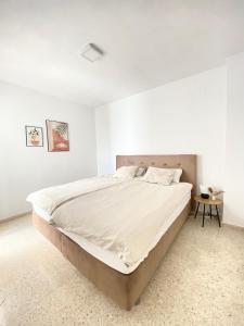 EsteponaTownhouse w/sea view & garden的白色卧室配有一张大床和一张桌子