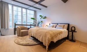 豪达Hofje van Sint Jan的一间卧室配有一张床、一把椅子和窗户。