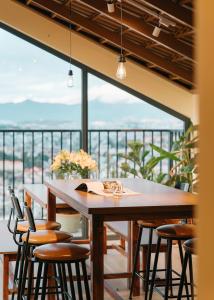 大叻Miền Sương Khói Homestay Đà Lạt的阳台的用餐室配有桌椅