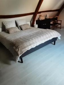 Capelle-FermontLa grange de Fermont的一间卧室配有一张大床和木制床头板