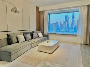 上海Shanghai Shining River Apartment -Near the Bund的带沙发和大窗户的客厅