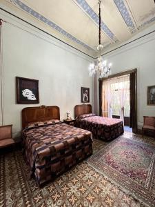 普埃布拉卡萨德拉帕尔马精品酒店的一间卧室配有两张床和吊灯。