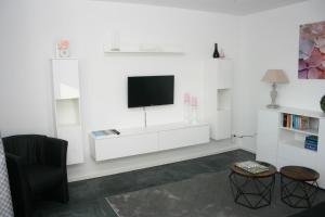 克莱沃Ferienwohnung Die Idyllische mit Sauna的一间客厅,在白色的墙上配有电视