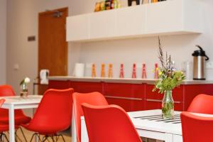 雷克雅未克海斯莫克酒店的餐厅设有红色的椅子和一张花瓶桌子