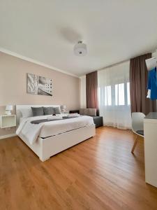 梅斯特Corso Venezia的白色的卧室设有一张白色的大床和木地板