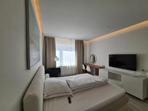 汉诺威Soleil Rooms - Pure Living in the City Center的配有一张床和一台平面电视的酒店客房