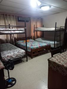戴维PaCasa Hostel的客房设有三张双层床和一张桌子。