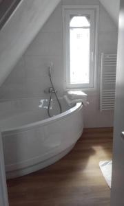 坎佩尔Maison rénovée atypique, jardin, terrasse, Odet的白色的浴室设有浴缸和窗户。