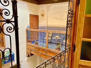 非斯Riad Noor Medina的客房铺有蓝色和白色瓷砖,设有楼梯。