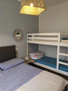 格罗塞托港Bilocale a 40 mt. dalla spiaggia circondato dalla pineta的一间卧室配有两张双层床和一盏灯。