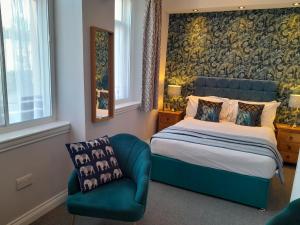 托基布里埃尔菲尔兹旅馆的一间卧室配有一张床和一张蓝色椅子